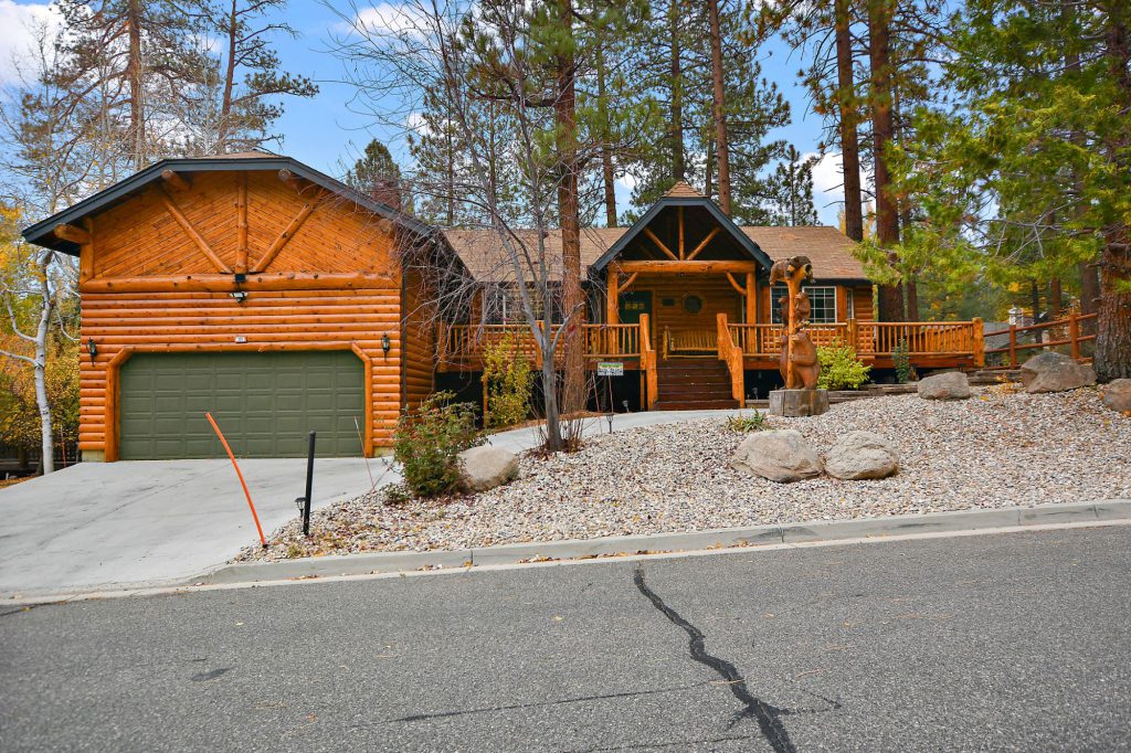 The Crazy Bear cabin in Big Bear features a spacious house with a garage and a long driveway.