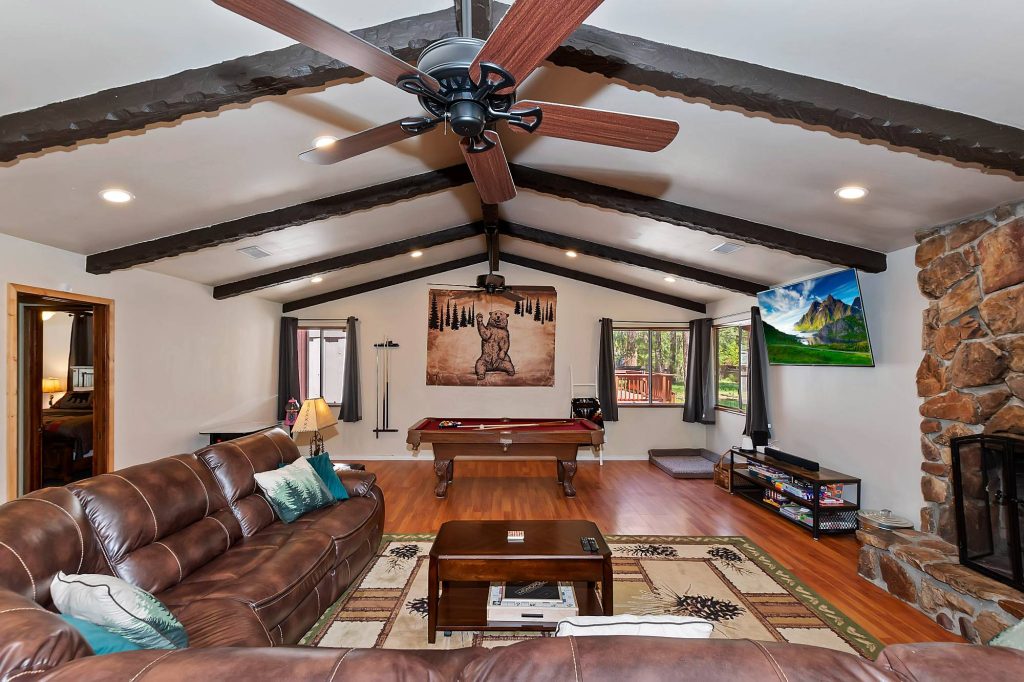 Spacious game room with leather seating, pool table, fireplace, and large television at The Ginger Lodge