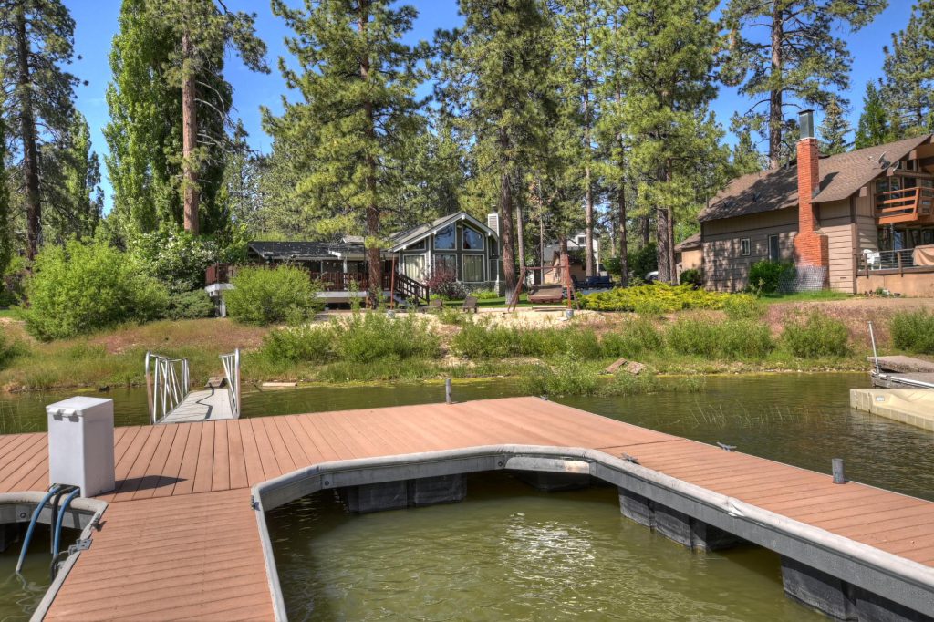 A lakeside dock with cabins and tall pine trees in Big Bear.