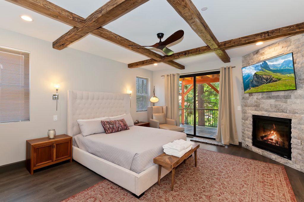 Stylish bedroom with beamed ceiling and fireplace in Big Bear.