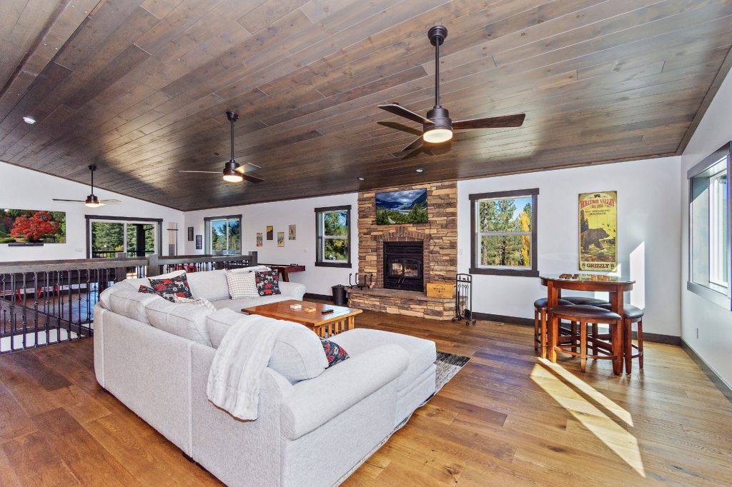 Modern luxury cabin living room with fireplace, wooden ceiling, and mountain retreat interior design