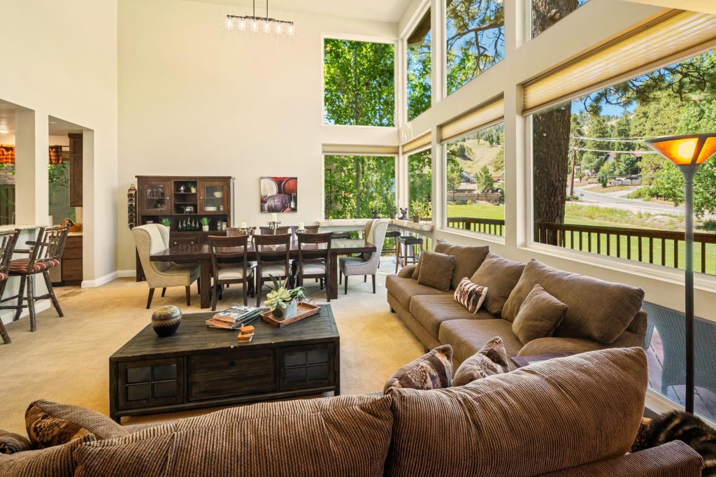 Spacious living room with large windows overlooking forested mountains