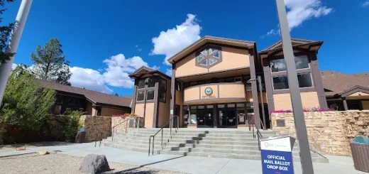 Front view of the Big Bear Lake Performing Arts Center featuring a flagpole in front of the large building.