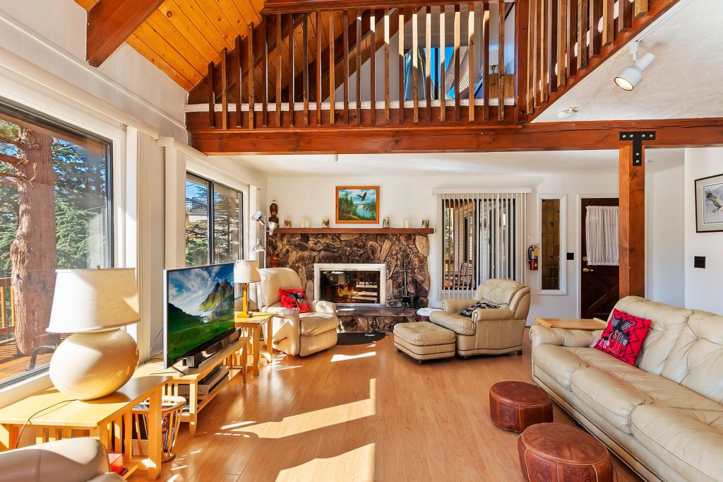 A woman and a child pose for a photo in front of the Big Bear Visitors Center and Chamber of Commerce sign.