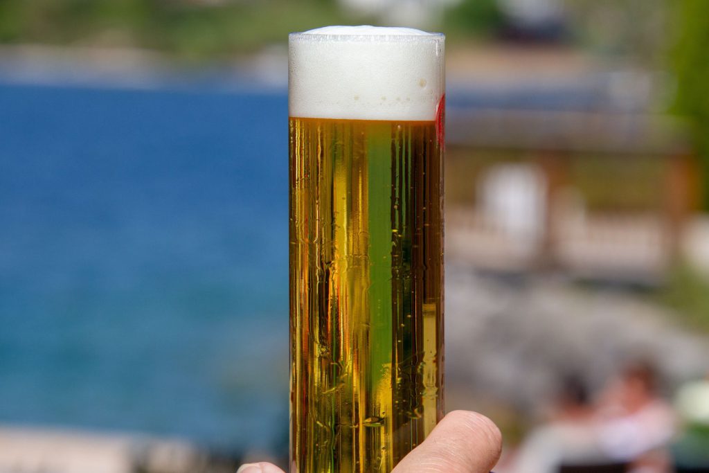 Cold craft beer in tall glass with foam head at Big Bear festival and outdoor event