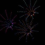 Drones are arranged to look like three multi-colored fireworks exploding against the dark night sky during a show in Big Bear.