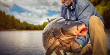 Angler holding large fish during Big Bear Lake fishing event