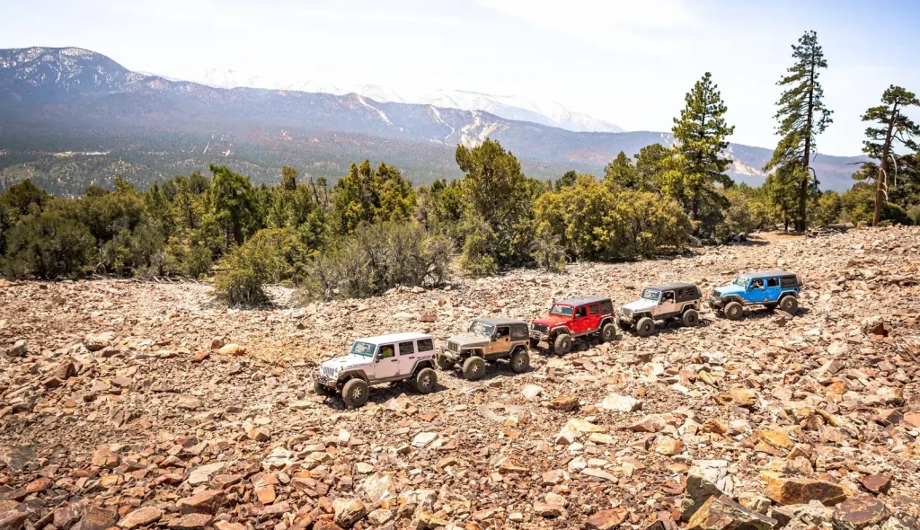 Four off-road jeeps parked on a rocky hillside in Big Bear, showcasing the rugged landscape and outdoor adventure.