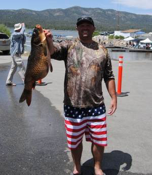 Angler holding large fish at Big Bear Lake during fishing event