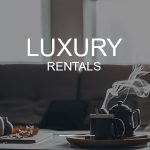 A cozy indoor scene features a steaming teapot and mug on a tray, with "LUXURY RENTALS" superimposed, indicating a selection of high-end accommodations