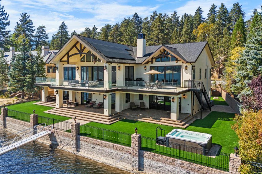 Spacious lakefront home in Big Bear with hot tub, dock, and forest backdrop.