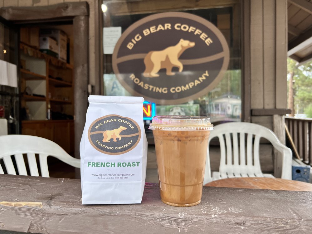 A bag of French toast coffee from Coffee Roasting Company in Big Bear, sits on a table beside a steaming cup of coffee.