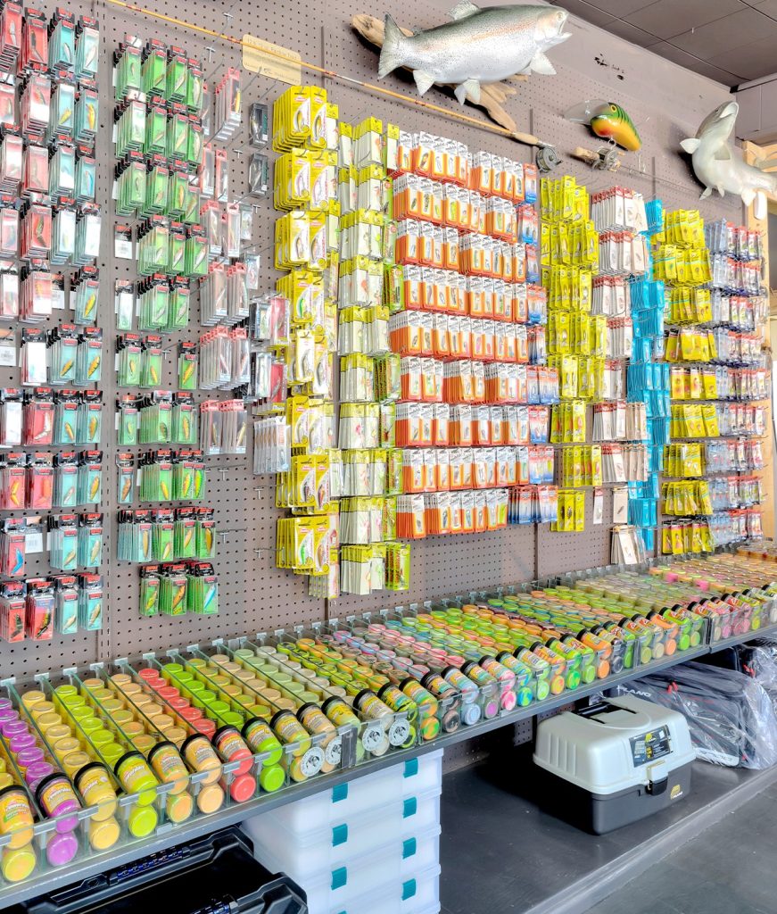Close-up interior wall display of colorful fishing lures, tackle boxes, and gear inside Big Bear Sporting Goods store