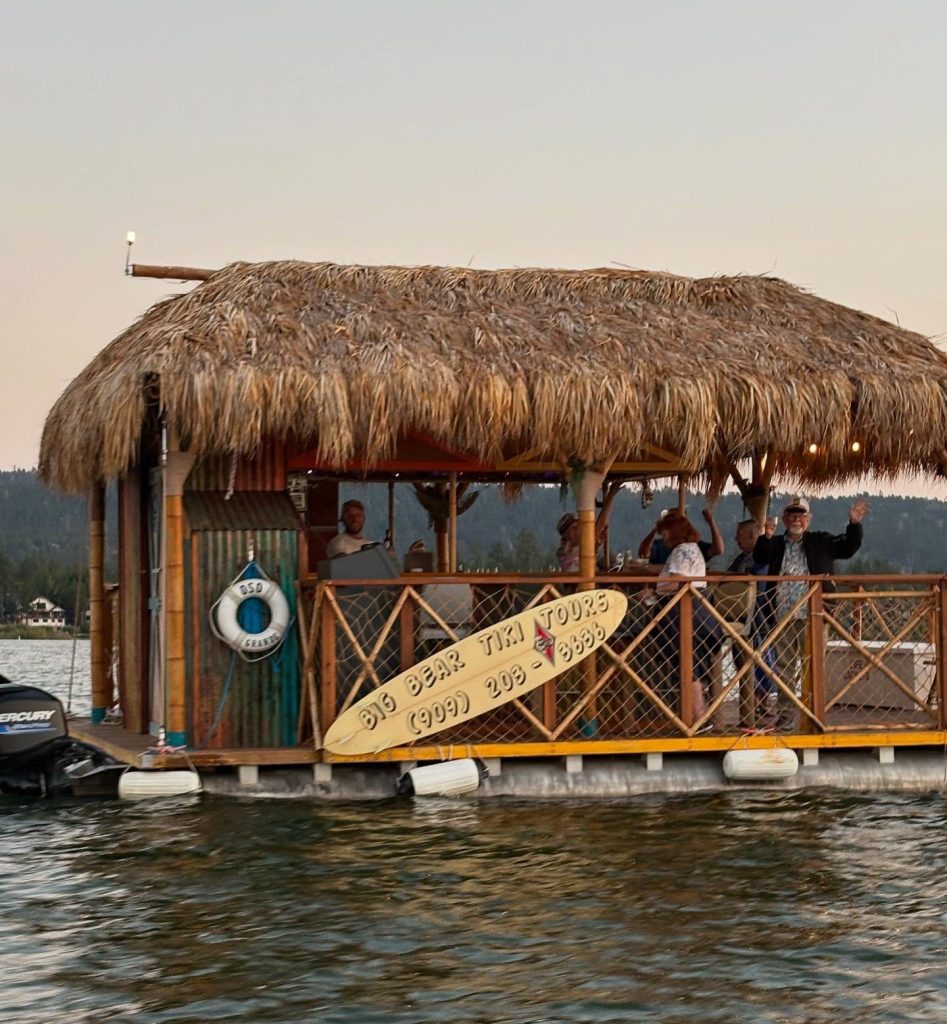 Floating tiki boat tour on Big Bear Lake with guests enjoying a relaxing lake cruise experience.