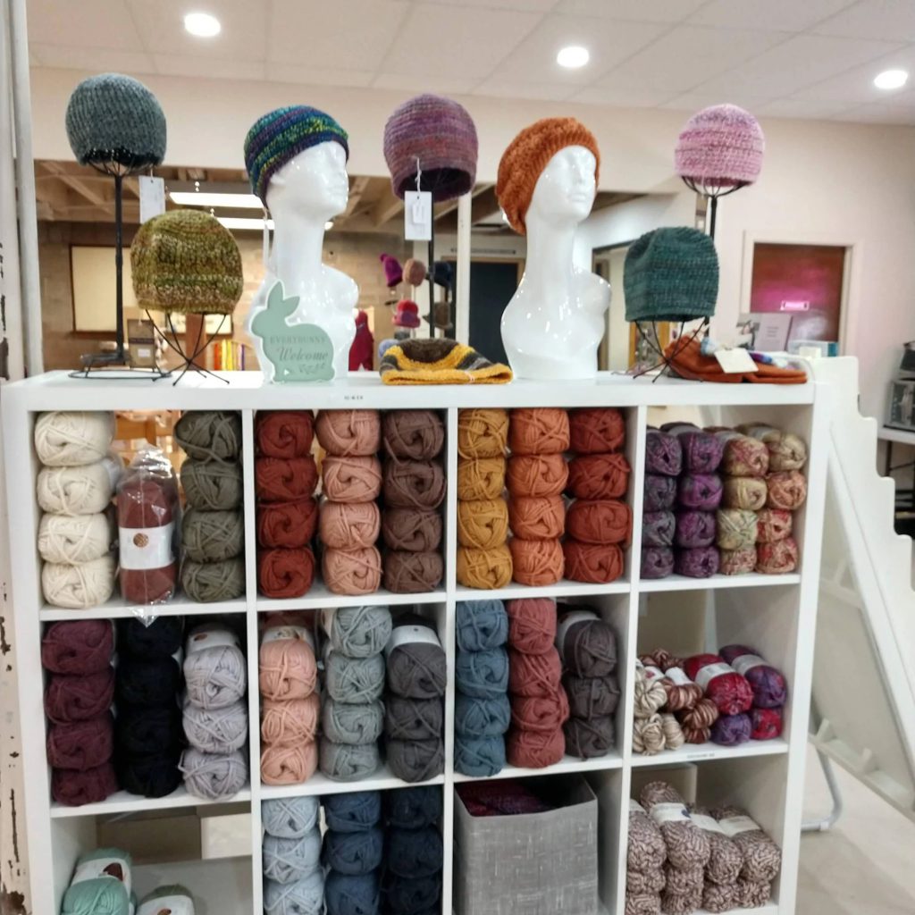 Colorful yarn and knitted hats display at Big Bear Yarn Co