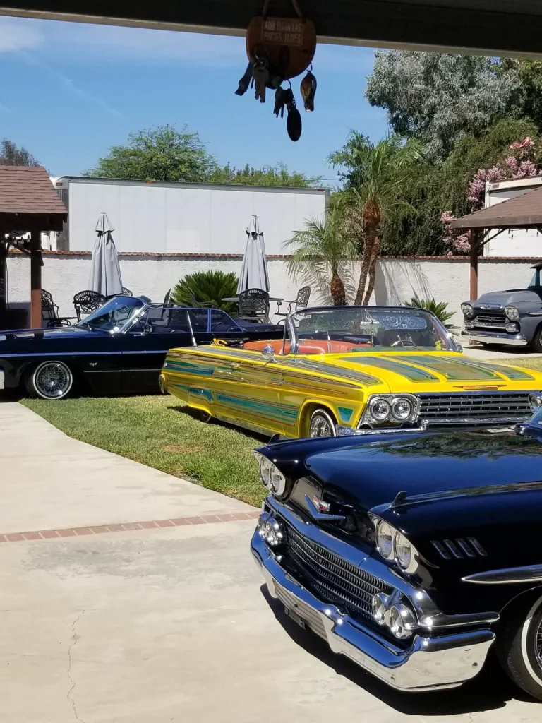 A lineup of classic cars parked in a driveway during the Big Bear Lake Lowrider Invasion event.