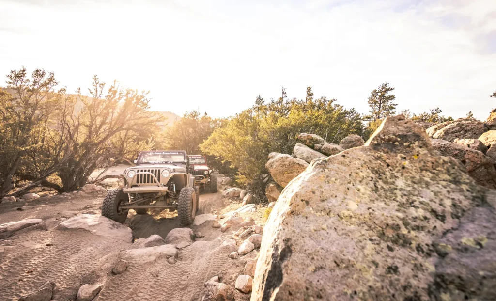 A jeep navigating a rocky trail in the desert, surrounded by rugged terrain and sparse vegetation near Big Bear.