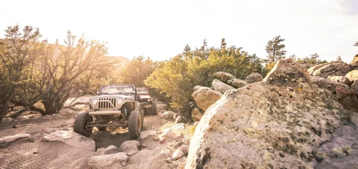 A jeep navigating a rocky trail in the desert, surrounded by rugged terrain and sparse vegetation near Big Bear.