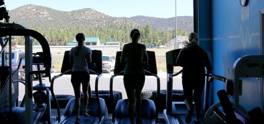 People running on treadmills inside BodyTek Fitness with a scenic mountain view in Big Bear