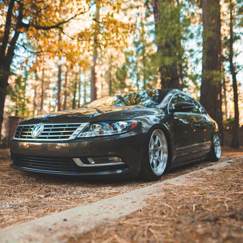 Low-angle shot of a lowered gray Volkswagen CC parked in a forest setting at Renntober Big Bear event.