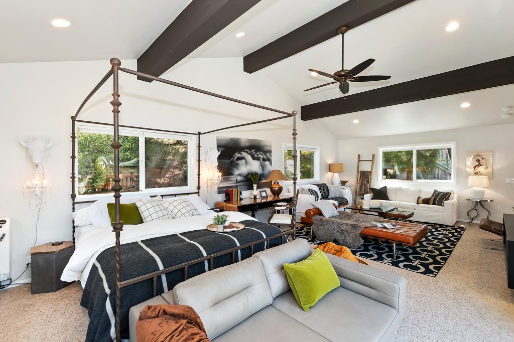 A spacious master suite with a four-poster bed and a living area in a Big Bear home.