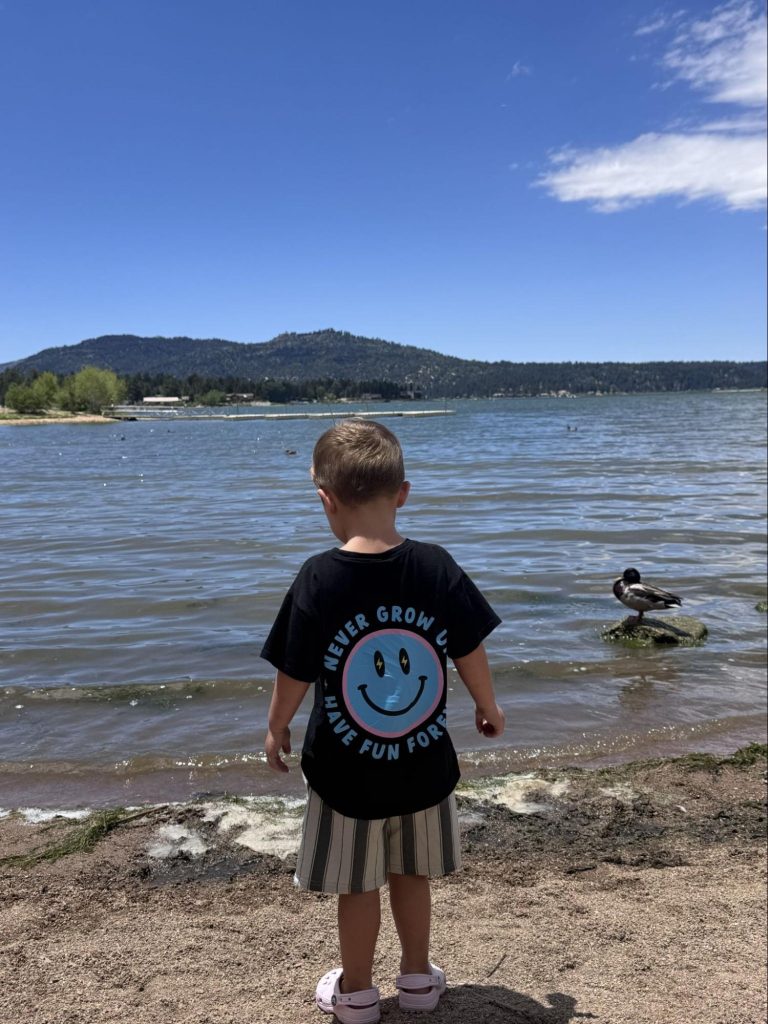 Child standing on the shoreline of Big Bear Lake enjoying scenic mountain and lake views.