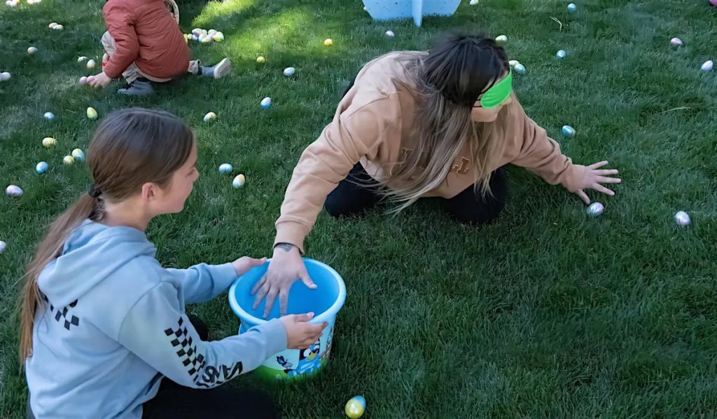 Kids and adults participating in blindfolded Easter egg hunt at Big Bear Lake
