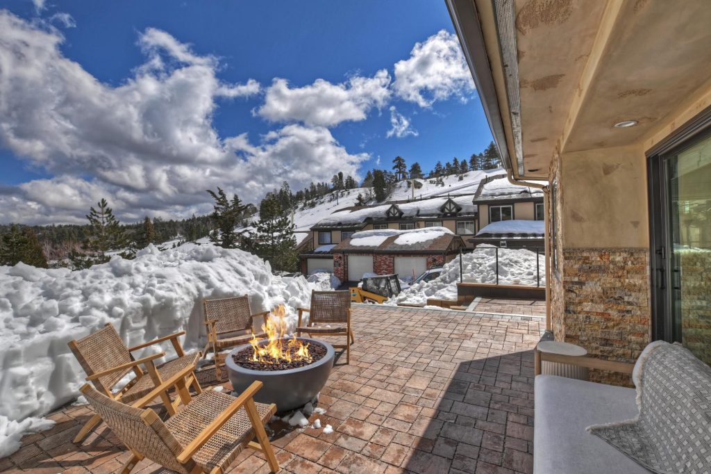 Fire pit on snowy patio at Apres Bear Mountain Retreat with mountain views