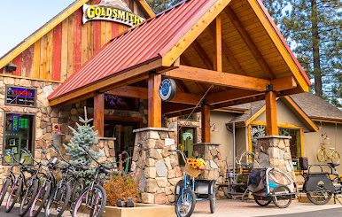The exterior of the Goldsmiths retail shop in Big Bear, showcasing a variety of bicycles and a bike trailer in front.