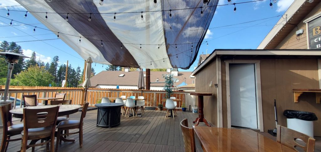 Outdoor patio seating at Himalayan Restaurant in Big Bear with string lights and canopy