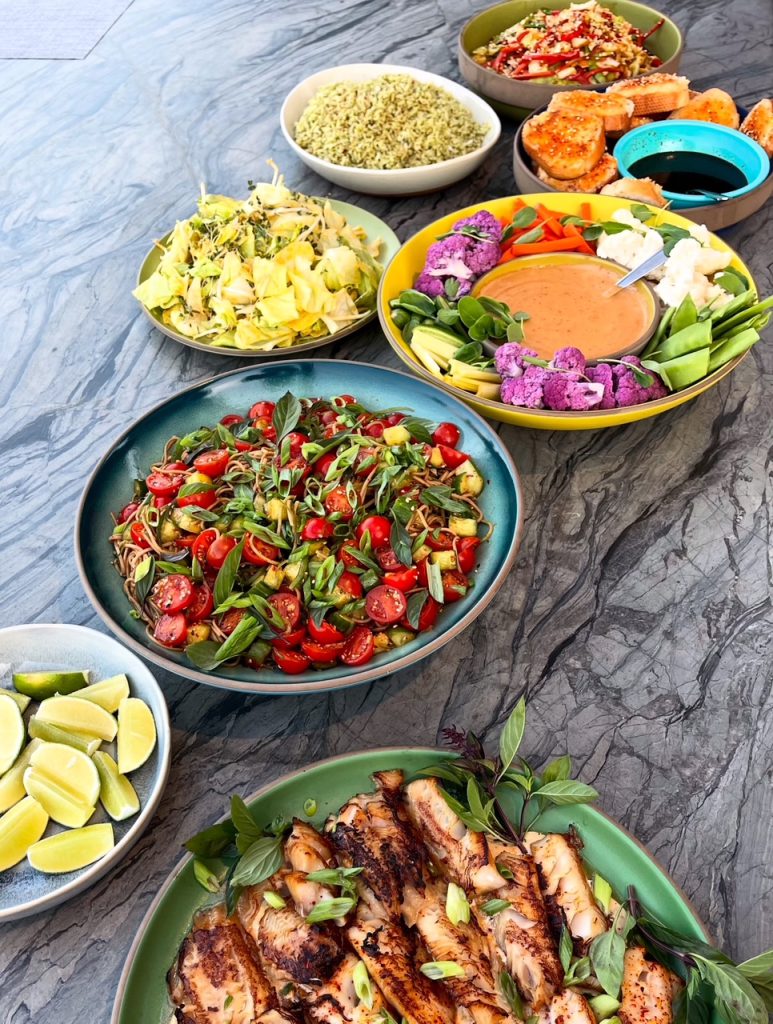 A table filled with various plates of food, showcasing a feast prepared by Dawson the Cook in Big Bear.