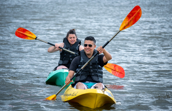 Couple kayaking together on Big Bear Lake while enjoying an outdoor mountain water adventure