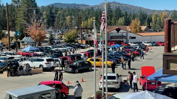 Car enthusiasts gathering with various cars on display at Renntober Big Bear.