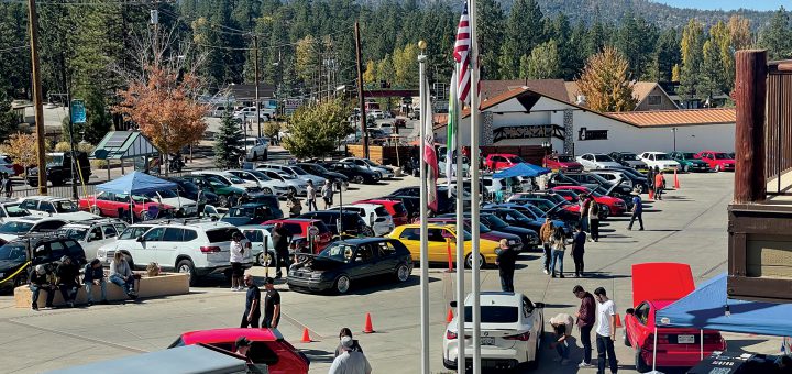 Car enthusiasts gathering with various cars on display at Renntober Big Bear.