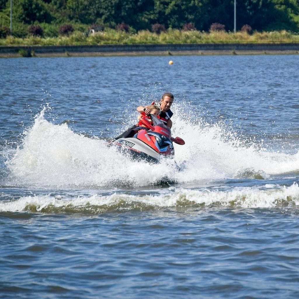 Man riding a jet ski on Big Bear Lake creating splashes on the water
