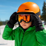 Young child adjusting ski goggles in a bright green jacket before hitting the slopes at Big Bear.