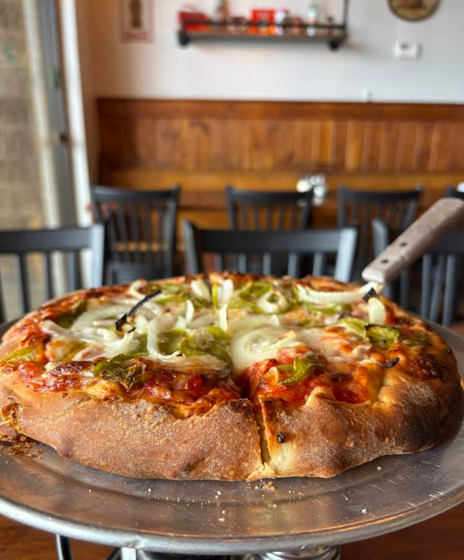 Fresh handmade pizza with melted cheese, onions, and peppers served at Maggio’s Pizza in Big Bear Lake