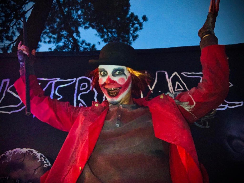 Creepy clown performer with red coat and hat at Mystery Maze in Big Bear