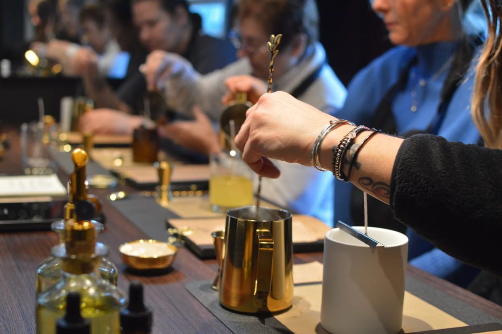 A group of people mixing fragrance oils during a candle-making workshop at Mystic Moto.