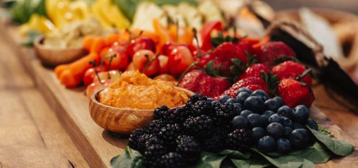 A colorful platter of fruit and vegetables with dip on a wooden tray, set against a rustic background in Big Bear.