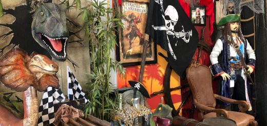 pirate-themed movie props and dinosaur displays inside Hollywood Land attraction