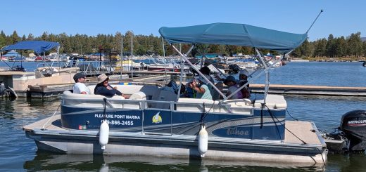 Family enjoying a pontoon boat ride at Pleasure Point Marina in Big Bear Lake