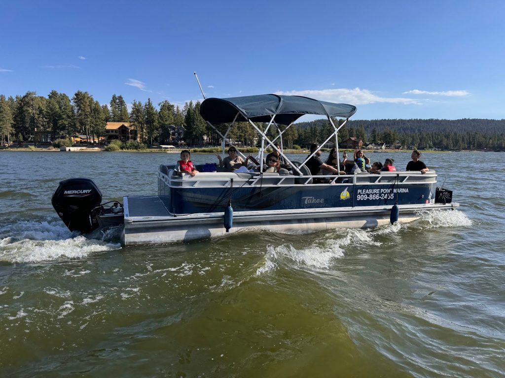 Group riding a pontoon boat on Big Bear Lake enjoying water recreation