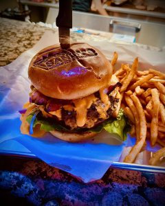 A knife rests on the table beside a cheeseburger and fries at Sandy's restaurant in Big Bear.