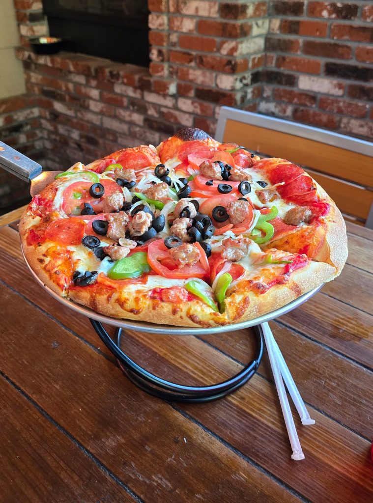 Loaded pizza topped with pepperoni, sausage, olives, peppers, and tomatoes served at Saucy Mama’s Pizza in Big Bear Lake