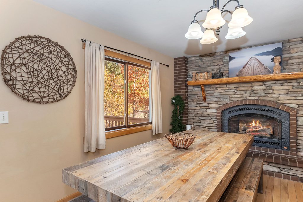 Cozy rustic dining area with stone fireplace at Big Bear.