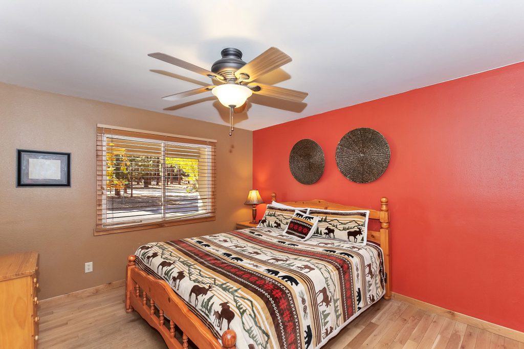 Bright bedroom with rustic decor and red accent wall in Big Bear.
