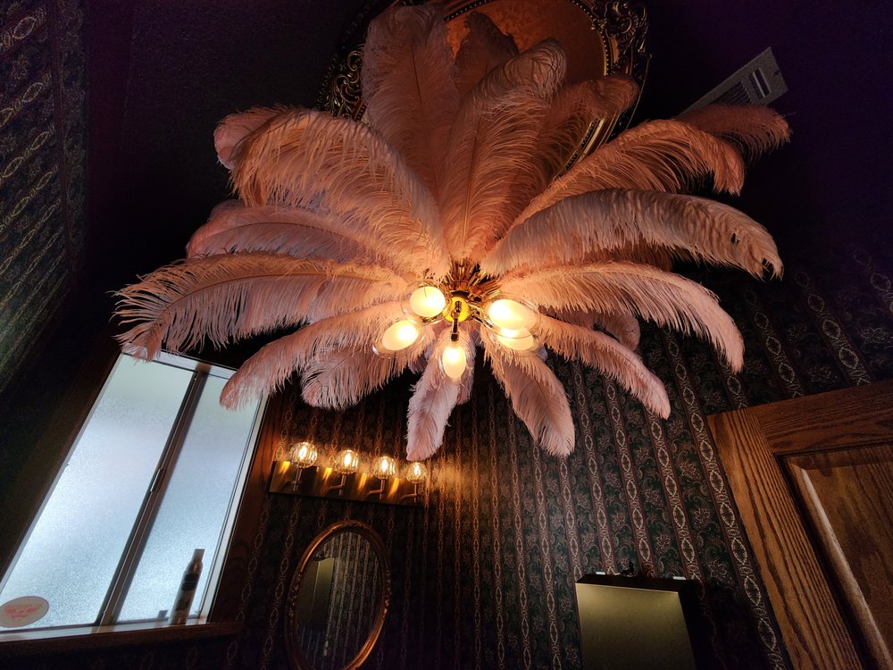 A unique ceiling light fixture with large feathers and multiple bulbs illuminates a spa room at Big Bear.
