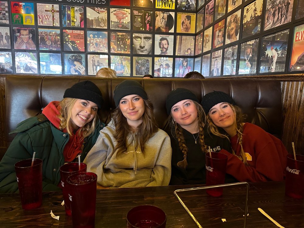 Group of friends enjoying food and drinks inside Saucy Mama’s Pizza and Beer restaurant in Big Bear Lake