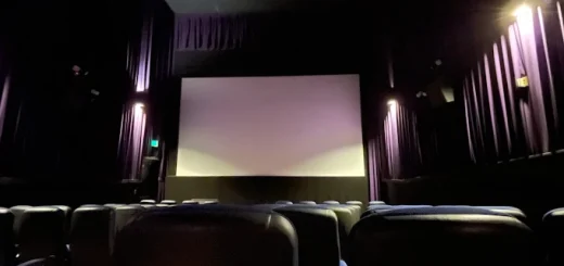 A theater interior at Village Theaters, Big Bear Lake, featuring rows of chairs facing a large screen.